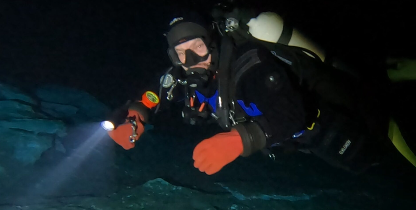 Diver team preparing cave diving route plans and equipment